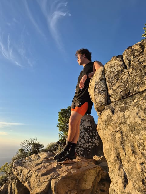 Tudor James Grimbly standing on a rock in late golden light